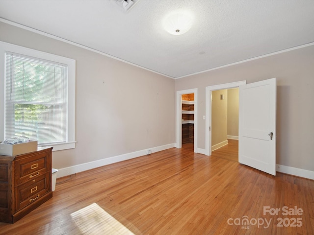 729 Montgomery Ave, Albemarle, NC 28001 - unfurnished bedroom featuring crown molding, light wood finished floors, baseboards, and a closet