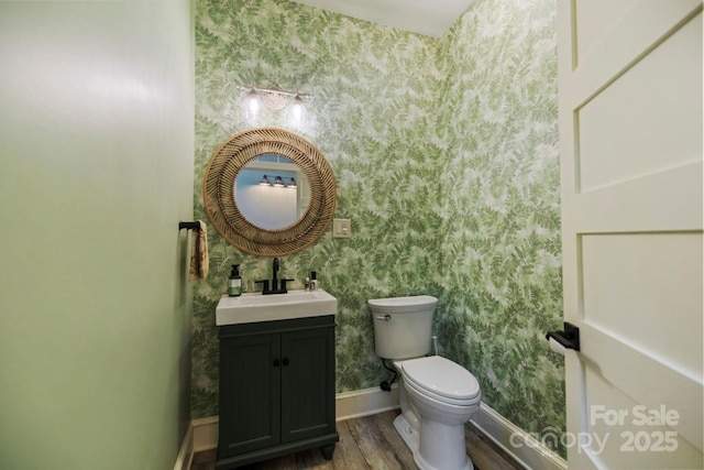 231 Bible School Rd, Lake Lure, NC 28746 - half bath featuring wallpapered walls, wood finished floors, vanity, toilet, and baseboards