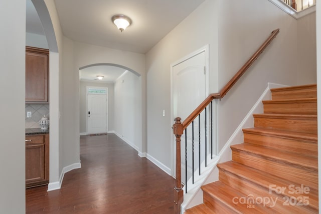 11922 Kimberfield Rd, Matthews, NC 28105 - foyer entrance with arched walkways, dark wood-style floors, and stairs