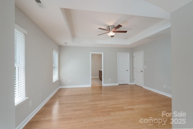 11922 Kimberfield Rd, Matthews, NC 28105 - spare room featuring ceiling fan, a tray ceiling, and light wood-style flooring