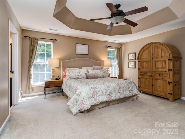 7700 Antique Cir, Waxhaw, NC 28173 - carpeted bedroom with multiple windows, a ceiling fan, and a tray ceiling