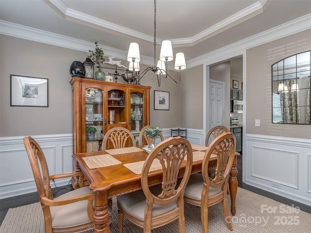 7700 Antique Cir, Waxhaw, NC 28173 - dining room with a decorative wall, a chandelier, wainscoting, and crown molding