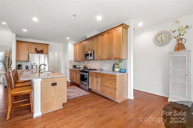 2399 Ashbourne Pl SE, Concord, NC 28025 - kitchen with appliances with stainless steel finishes, tasteful backsplash, light wood finished floors, light stone countertops, and recessed lighting