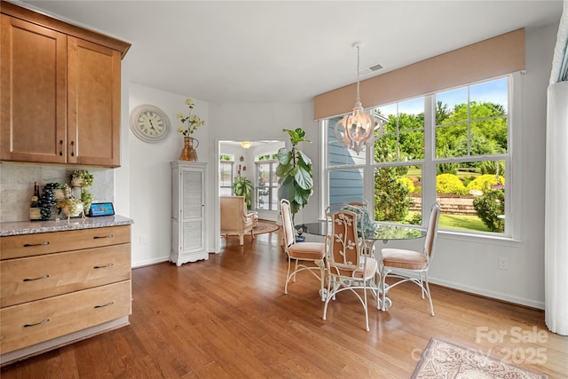 2399 Ashbourne Pl SE, Concord, NC 28025 - dining space featuring a chandelier, wood finished floors, and plenty of natural light