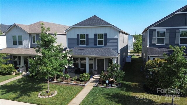 11965 Hambright Rd, Huntersville, NC 28078 - view of front facade with board and batten siding, a front lawn, and roof with shingles