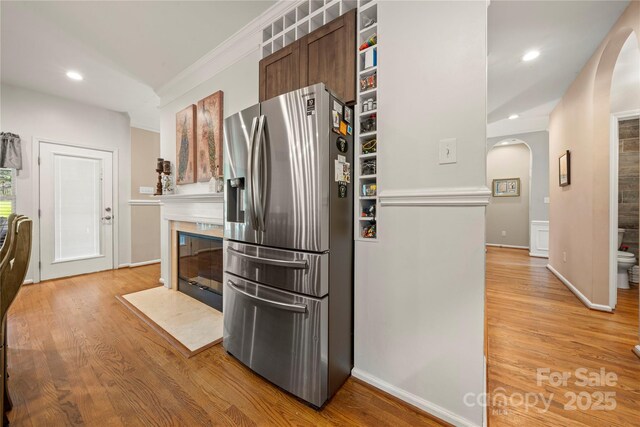 162 Castles Gate Dr, Mooresville, NC 28117 - kitchen featuring stainless steel refrigerator with ice dispenser, arched walkways, light wood-type flooring, a tiled fireplace, and recessed lighting