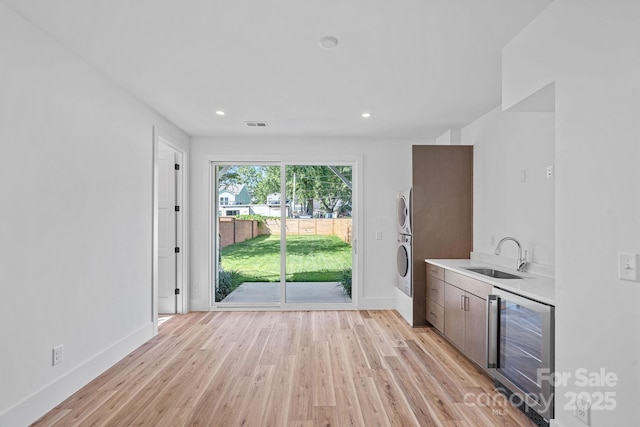 209 Keswick Ave, Charlotte, NC 28206 - kitchen featuring wine cooler, stacked washer / dryer, light countertops, light wood-style floors, and recessed lighting