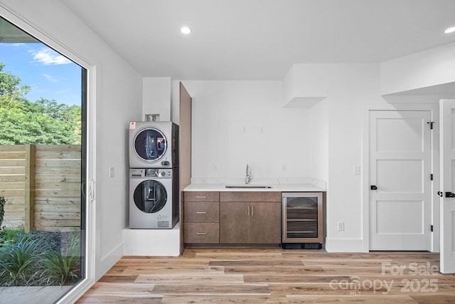 209 Keswick Ave, Charlotte, NC 28206 - laundry area featuring wine cooler, stacked washer and clothes dryer, bar with sink, light wood-style flooring, and recessed lighting