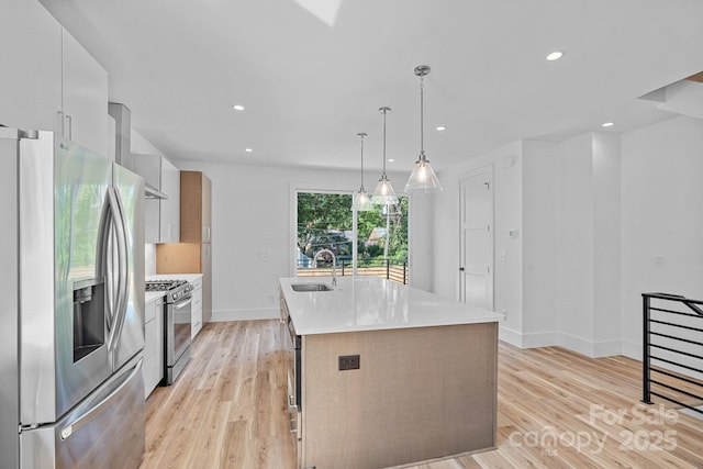 209 Keswick Ave, Charlotte, NC 28206 - kitchen featuring appliances with stainless steel finishes, a kitchen island with sink, modern cabinets, light countertops, and light wood-style flooring