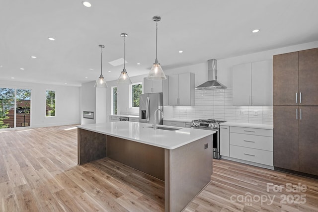 209 Keswick Ave, Charlotte, NC 28206 - kitchen with wall chimney range hood, appliances with stainless steel finishes, healthy amount of natural light, an island with sink, and recessed lighting