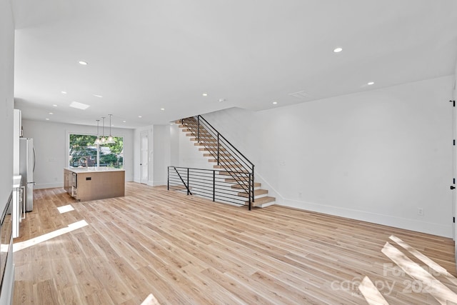 209 Keswick Ave, Charlotte, NC 28206 - unfurnished living room with light wood-style flooring, stairway, and recessed lighting