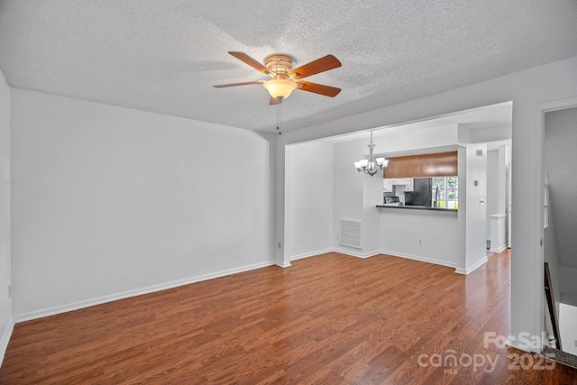 218 Water Oak Dr, Pineville, NC 28134 - unfurnished living room with a chandelier, ceiling fan, wood finished floors, and a textured ceiling