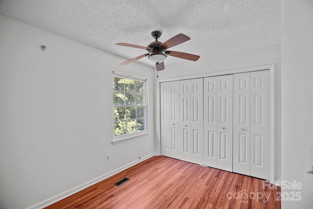 218 Water Oak Dr, Pineville, NC 28134 - unfurnished bedroom with a textured ceiling, light wood finished floors, a closet, and a ceiling fan