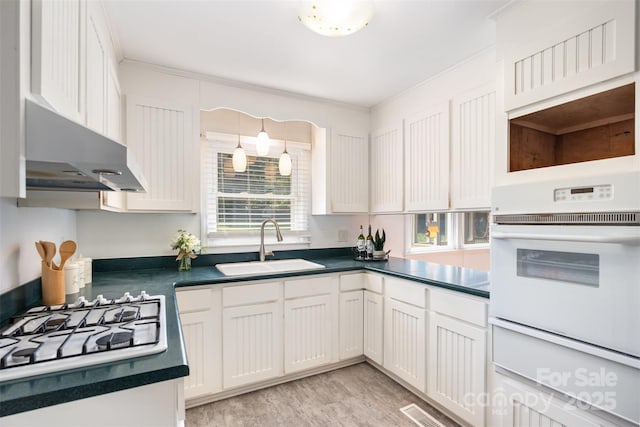1925 Montclair Ave, Gastonia, NC 28054 - kitchen featuring white oven, stovetop, under cabinet range hood, and dark countertops