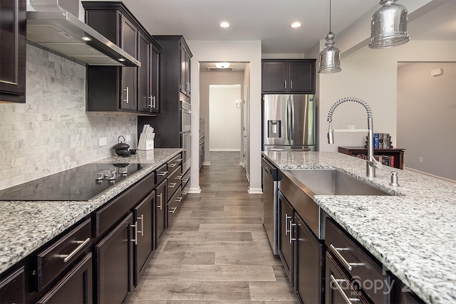 171 Old Harbor Dr, Mount Gilead, NC 27306 - kitchen with wall chimney range hood, stainless steel appliances, light stone countertops, decorative backsplash, and recessed lighting