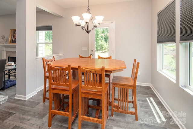 171 Old Harbor Dr, Mount Gilead, NC 27306 - dining area featuring healthy amount of natural light, wood finished floors, a chandelier, and a brick fireplace