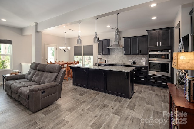 171 Old Harbor Dr, Mount Gilead, NC 27306 - kitchen with open floor plan, wall chimney exhaust hood, double oven, light wood finished floors, and recessed lighting