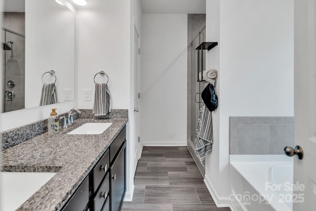 171 Old Harbor Dr, Mount Gilead, NC 27306 - bathroom with a stall shower, double vanity, a garden tub, and wood finished floors
