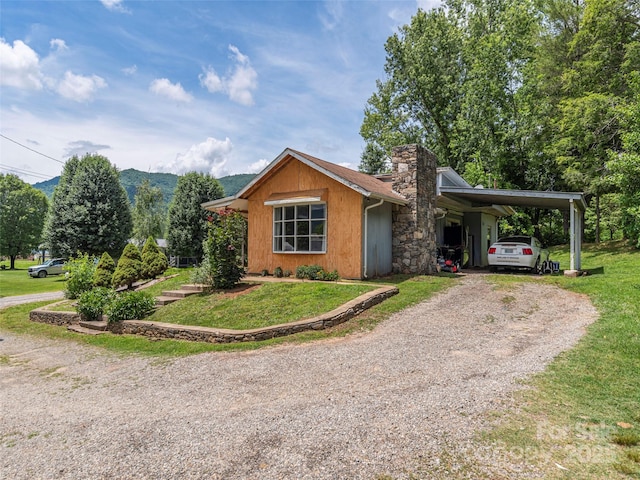 157 Evergreen Cir, Waynesville, NC 28786 - view of front of house with a chimney, a front yard, gravel driveway, and an attached carport