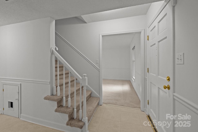 906 Wishing Well Ln, Charlotte, NC 28270 - stairs featuring tile patterned floors, a textured ceiling, and carpet flooring