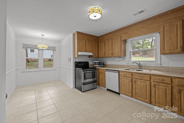906 Wishing Well Ln, Charlotte, NC 28270 - kitchen featuring appliances with stainless steel finishes, under cabinet range hood, brown cabinetry, light countertops, and a textured ceiling