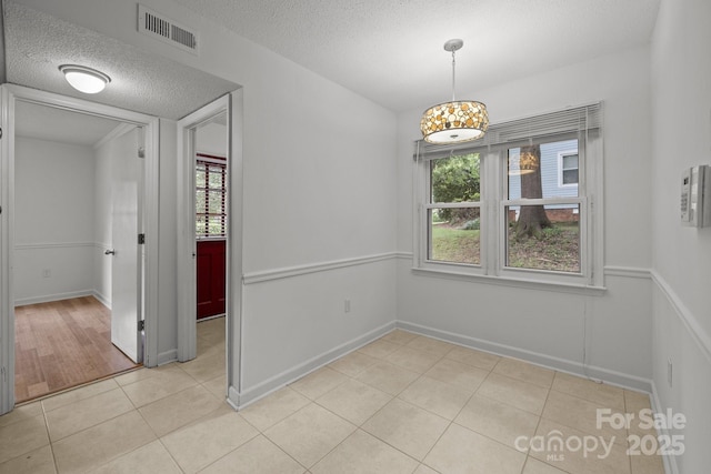 906 Wishing Well Ln, Charlotte, NC 28270 - unfurnished dining area featuring a textured ceiling and light tile patterned floors