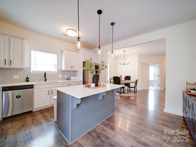 5121 Arbordale Way, Mount Holly, NC 28120 - kitchen featuring stainless steel dishwasher, decorative backsplash, white cabinets, light countertops, and wood finished floors