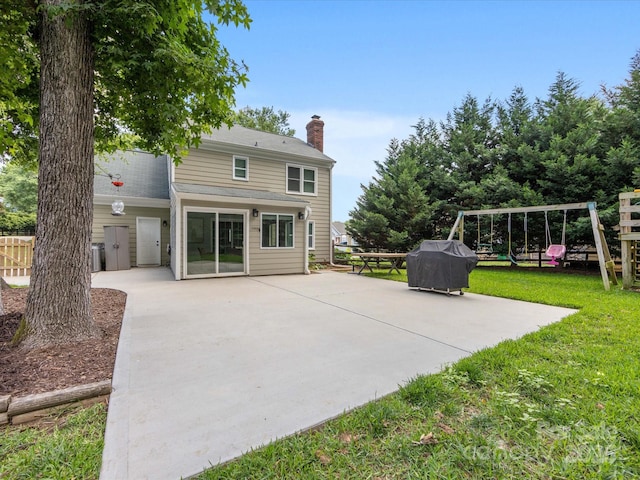 9908 Park Springs Ct, Charlotte, NC 28210 - back of house featuring a playground, a patio, a chimney, and a lawn
