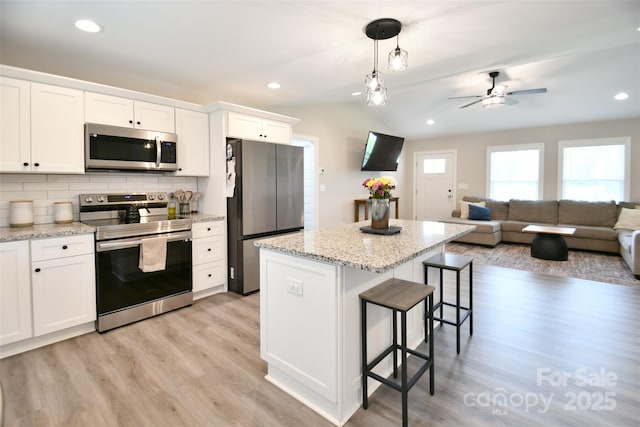 339 Brown Rd, China Grove, NC 28023 - kitchen featuring appliances with stainless steel finishes, a breakfast bar, a kitchen island, lofted ceiling, and light wood-style flooring