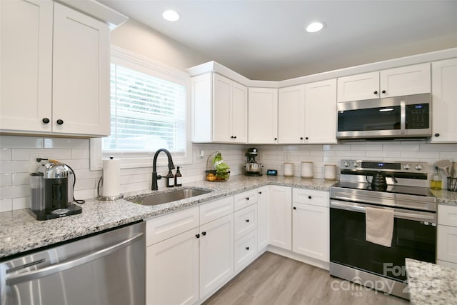 339 Brown Rd, China Grove, NC 28023 - kitchen with stainless steel appliances, tasteful backsplash, white cabinetry, light wood-type flooring, and recessed lighting