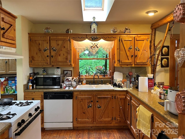 687 Willow Creek Rd, Leicester, NC 28748 - kitchen with white appliances, a skylight, brown cabinetry, light wood finished floors, and under cabinet range hood