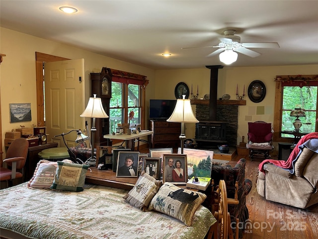 687 Willow Creek Rd, Leicester, NC 28748 - living area with wood finished floors, a ceiling fan, and a wood stove