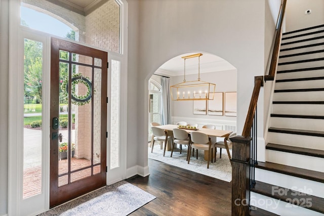 1032 Spyglass Ln, Waxhaw, NC 28173 - foyer with crown molding, stairway, arched walkways, dark wood-style floors, and a chandelier