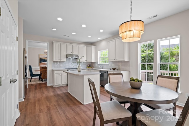 6803 Augustine Way, Charlotte, NC 28270 - kitchen with appliances with stainless steel finishes, light countertops, a kitchen island, backsplash, and under cabinet range hood