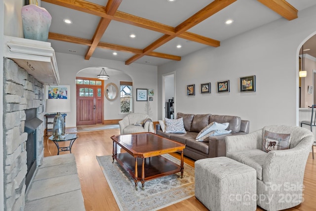 753 River Bend Dr, Granite Falls, NC 28630 - living room featuring arched walkways, light wood-style flooring, a fireplace, beam ceiling, and coffered ceiling