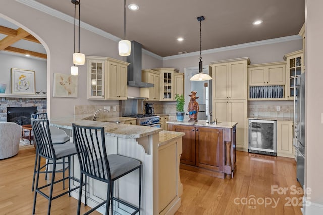 753 River Bend Dr, Granite Falls, NC 28630 - kitchen featuring cream cabinets, wine cooler, wall chimney range hood, a peninsula, and light wood finished floors