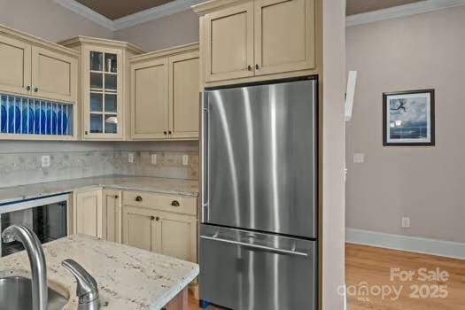 753 River Bend Dr, Granite Falls, NC 28630 - kitchen featuring stainless steel refrigerator, cream cabinetry, wood finished floors, ornamental molding, and glass insert cabinets