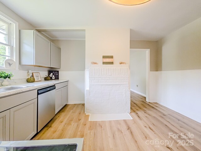 106 Cedar St, Spindale, NC 28160 - kitchen featuring dishwasher, light wood-style floors, a sink, light countertops, and baseboards