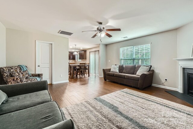 4151 Granite St, Midland, NC 28107 - living area with a ceiling fan, dark wood-type flooring, and a fireplace with raised hearth