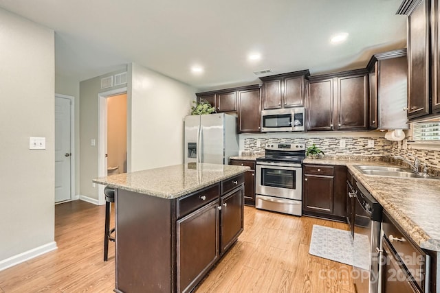 4151 Granite St, Midland, NC 28107 - kitchen featuring appliances with stainless steel finishes, light wood-type flooring, decorative backsplash, dark brown cabinets, and recessed lighting
