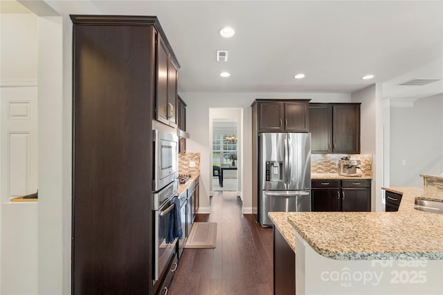 1830 Alden Oaks Ln, Charlotte, NC 28270 - kitchen featuring appliances with stainless steel finishes, dark brown cabinetry, backsplash, dark wood-style flooring, and light stone counters