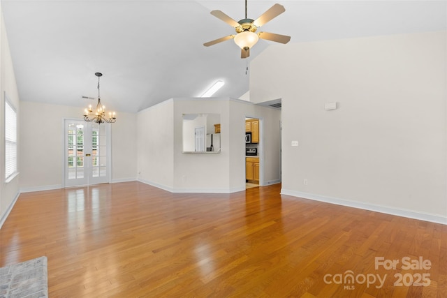 5707 Sustar Dr, Monroe, NC 28110 - unfurnished living room featuring ceiling fan, light wood-style flooring, a chandelier, high vaulted ceiling, and french doors