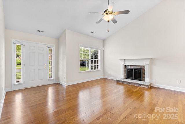 5707 Sustar Dr, Monroe, NC 28110 - unfurnished living room featuring light wood-style flooring, plenty of natural light, lofted ceiling, a brick fireplace, and ceiling fan