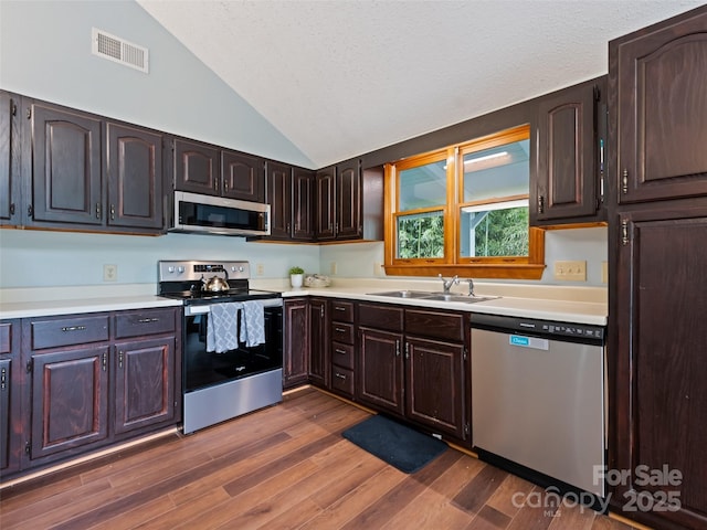 848 Eagles Ridge Rd, Sylva, NC 28779 - kitchen with stainless steel appliances, a sink, vaulted ceiling, light countertops, and dark wood-style floors