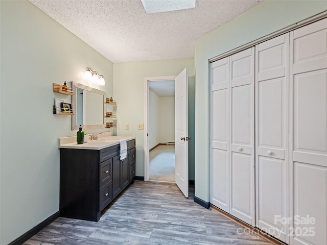 848 Eagles Ridge Rd, Sylva, NC 28779 - bathroom featuring vanity, a textured ceiling, wood finished floors, a closet, and baseboard heating