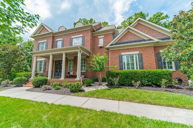 2004 Viscount Dr, Matthews, NC 28104 - colonial inspired home with a porch, brick siding, a chimney, and a front lawn