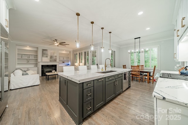 2004 Viscount Dr, Matthews, NC 28104 - kitchen with stainless steel dishwasher, white cabinetry, a ceiling fan, a fireplace, and ornamental molding