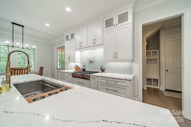 2004 Viscount Dr, Matthews, NC 28104 - kitchen with tasteful backsplash, white cabinetry, wood finished floors, ornamental molding, and stainless steel gas stovetop