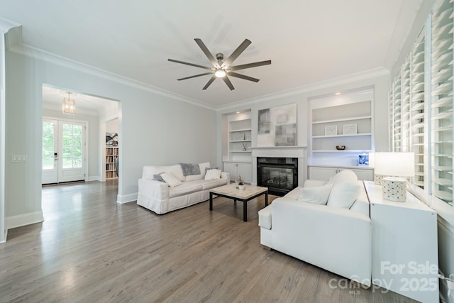 2004 Viscount Dr, Matthews, NC 28104 - living room with ornamental molding, wood finished floors, a ceiling fan, a glass covered fireplace, and built in shelves