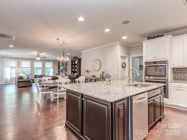 314 Candella Dr, Matthews, NC 28104 - kitchen with stainless steel appliances, open floor plan, a ceiling fan, white cabinetry, and crown molding